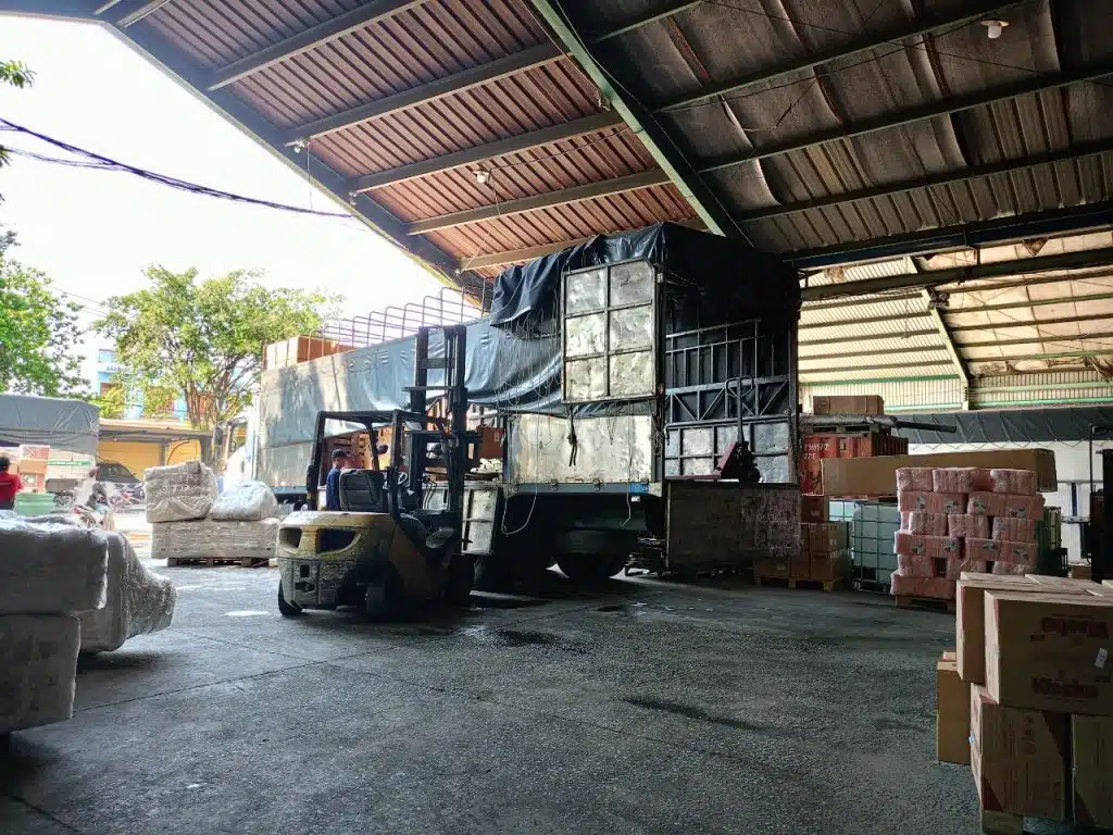 Xe nâng đưa kiện hàng lên xe tải thùng bạt trong kho chành xe Á Châu, hàng ghép chờ lên chuyến tuyến Bắc Nam