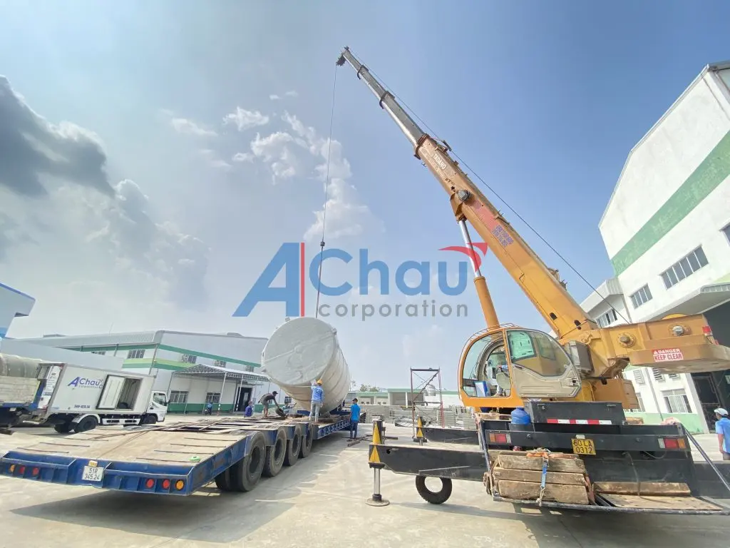 Cẩu chuyên dụng đặt bồn composite lên xe đầu kéo mooc sàn tại bãi hàng, chuyến hàng công trình của Á Châu