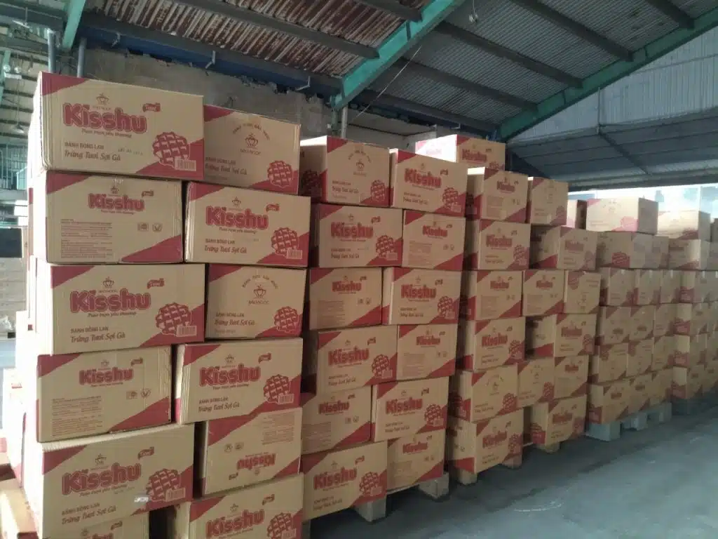 Thùng carton hàng tiêu dùng xếp cao trên pallet tại kho gom hàng ghép đi Phú Yên