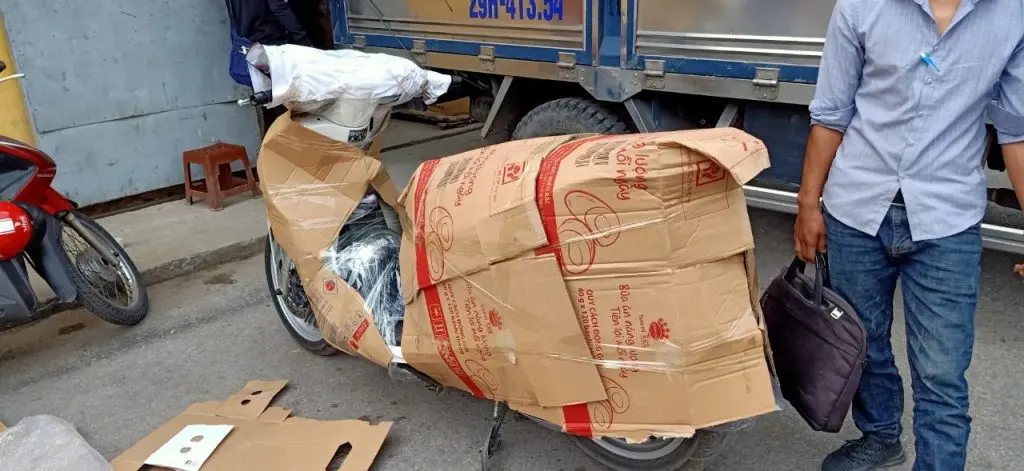 Xe máy được đóng thùng carton và quấn màng bảo vệ, chờ vận chuyển Bắc Nam
