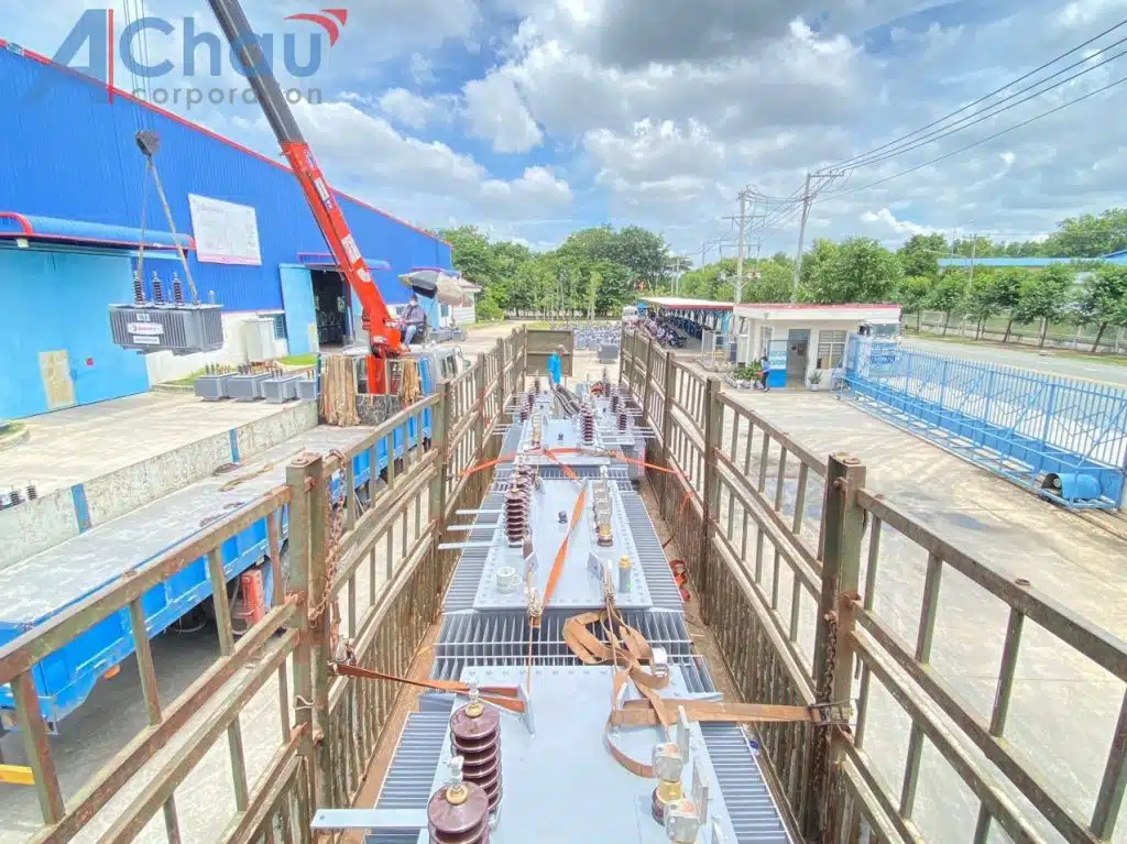 Cẩu tự hành Á Châu hạ thiết bị công nghiệp xuống thùng xe tại sân nhà máy