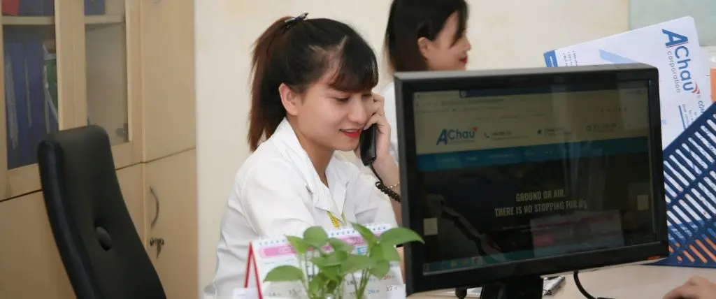Nhân viên tư vấn Vận Chuyển Á Châu làm việc tại văn phòng với hồ sơ và máy tính