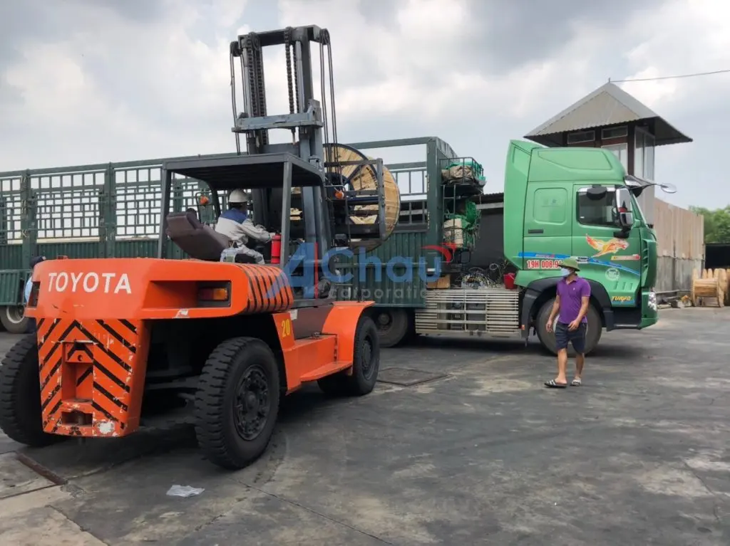 Xe nâng đưa rulô cáp lên xe tải thùng bạt tại bãi Á Châu, bên cạnh là đầu kéo mang biển số 19 của Phú Thọ