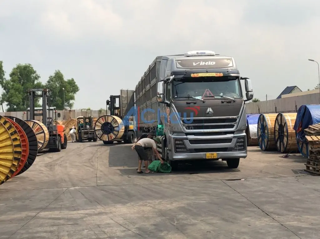 Bãi hàng Á Châu với đầu kéo và các cuộn cáp điện chờ xếp lên xe