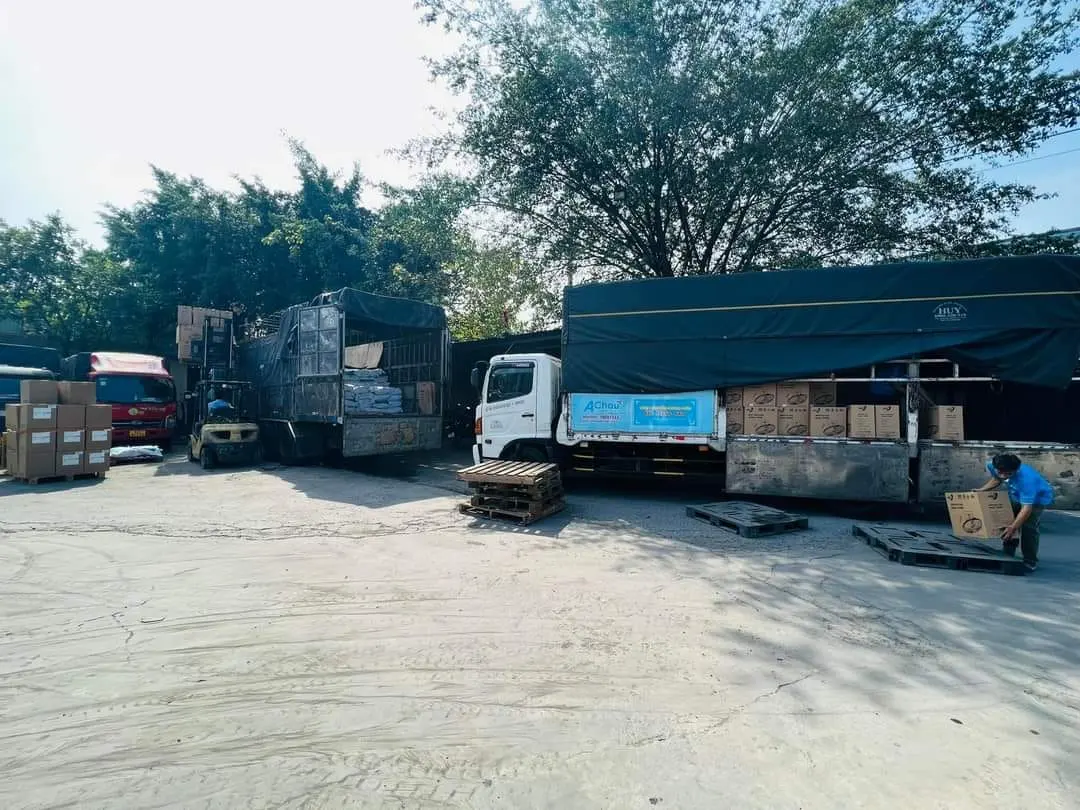 Xe mui bạt Á Châu mở bạt bên hông, xe nâng đưa thùng carton lên sàn xe tại bãi