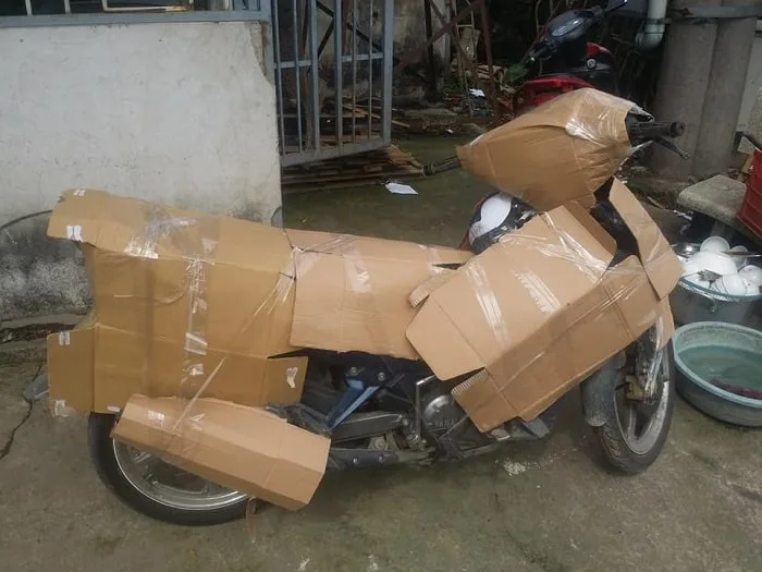Xe máy bọc carton và quấn băng keo kín trước khi xếp lên xe